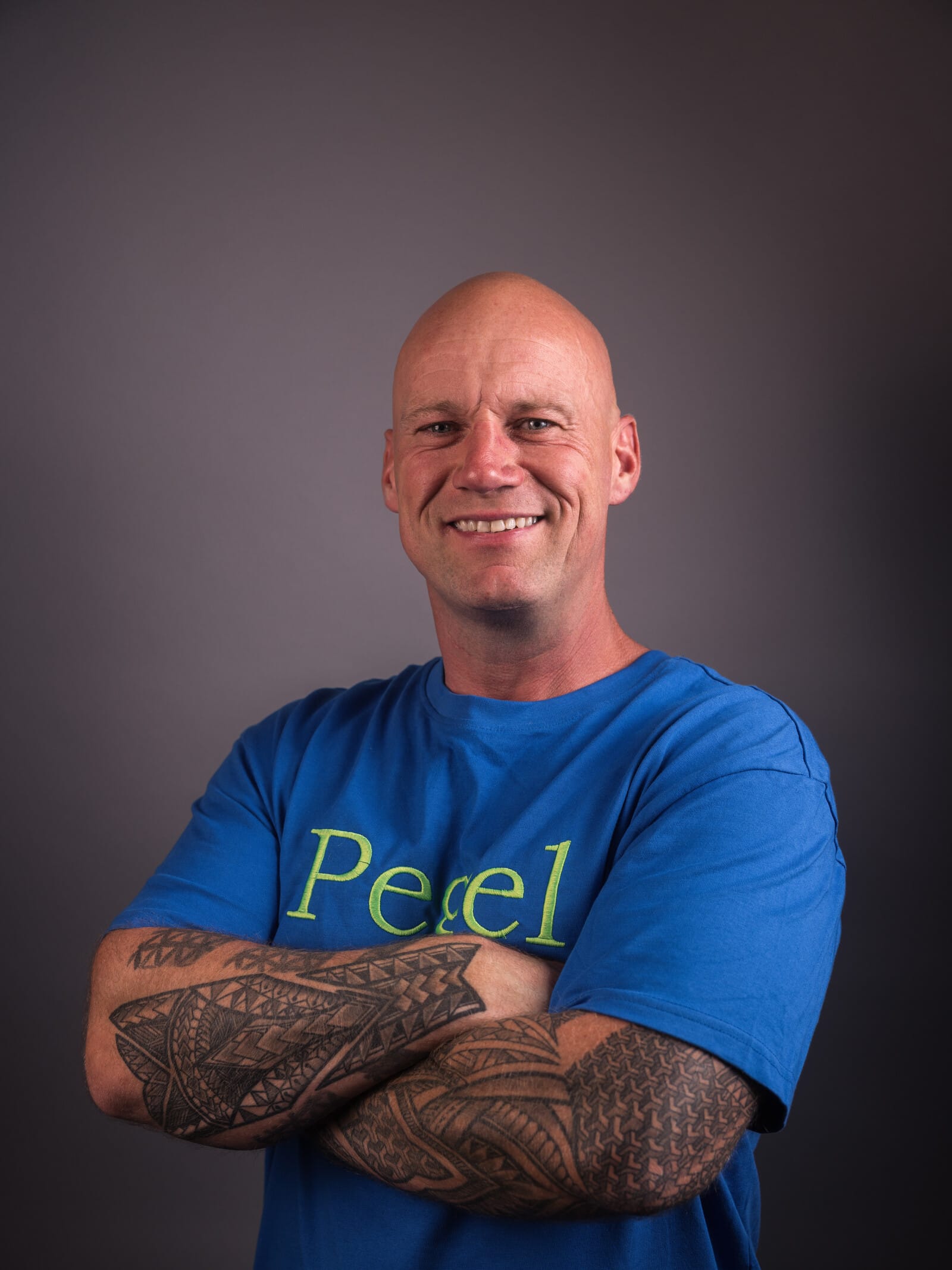 Pegel – Patrick Petersen im blauen Pegel-Shirt, Arme verschränkt, freundliches Studioporträt