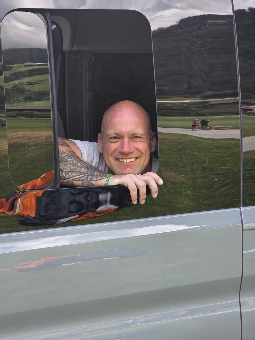 Pegel, lächelnd, mit Tattoo am Arm