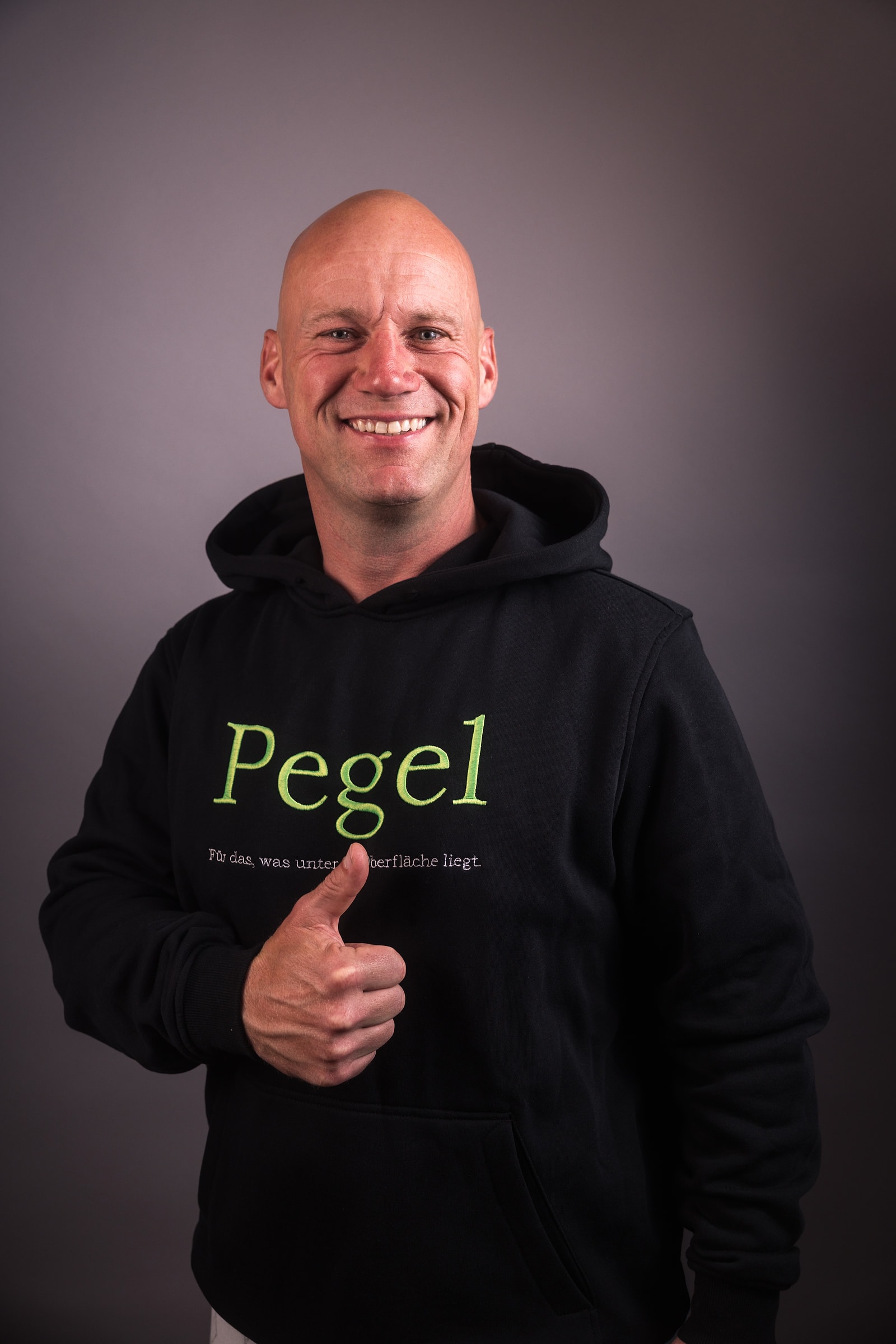 Pegel – Patrick Petersen, Studioporträt im schwarzen Pegel-Hoodie